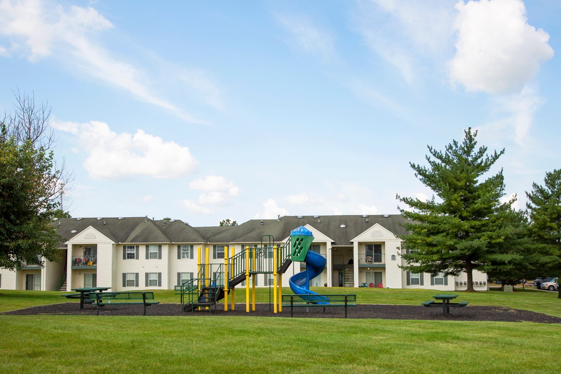 A playground in front of a large apartment building