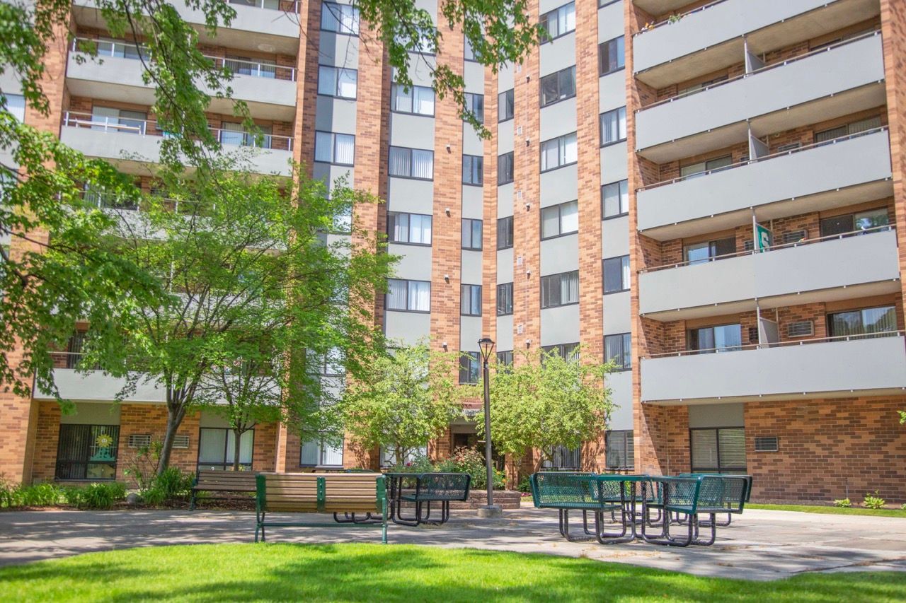 A large apartment building with a park in front of it.