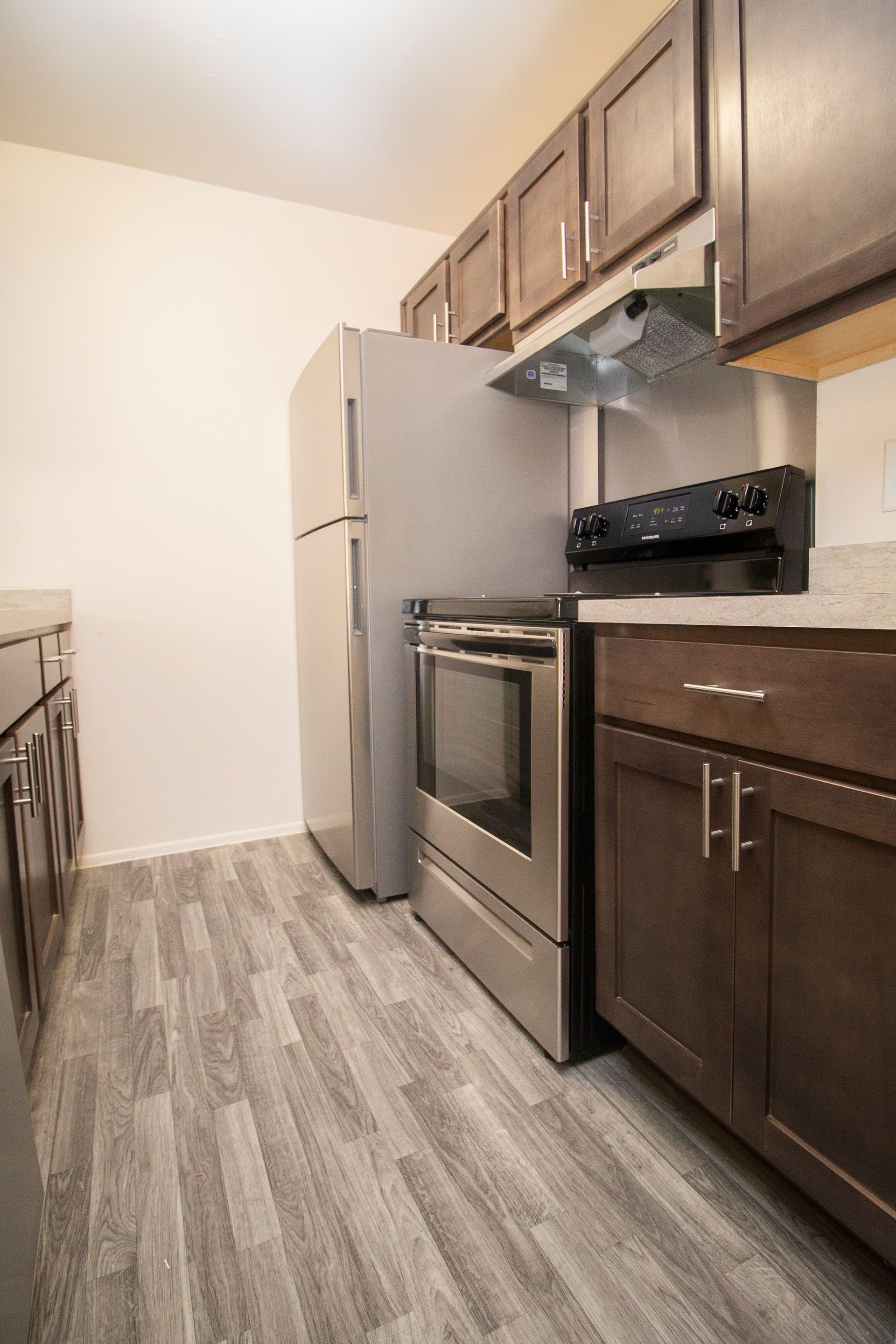 A kitchen with stainless steel appliances and wooden cabinets.
