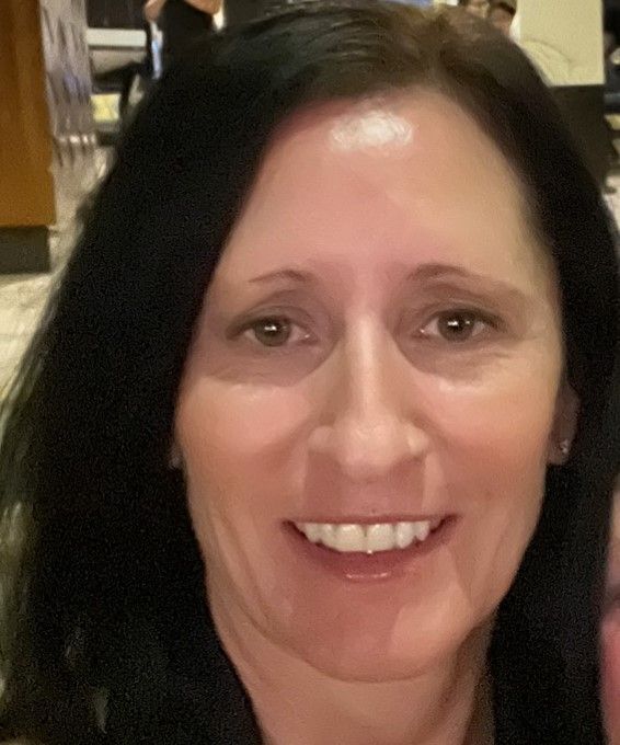 Smiling woman with dark hair in a warmly lit indoor setting