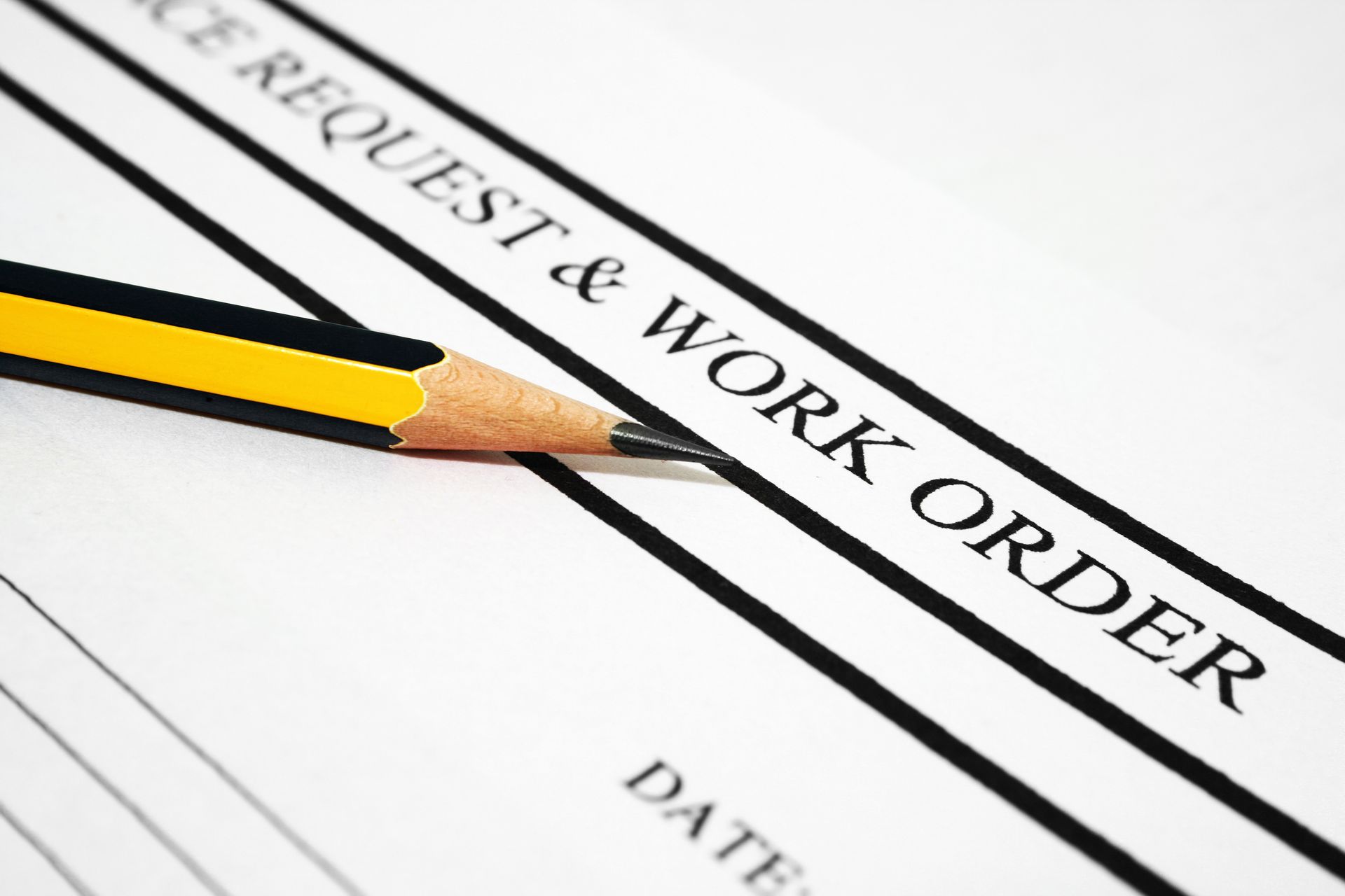 Pencil on a request and work order form with black and yellow stripes