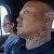 A man with a tattoo on his neck is sitting in a car