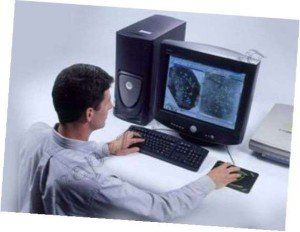 A man is sitting at a desk using a computer