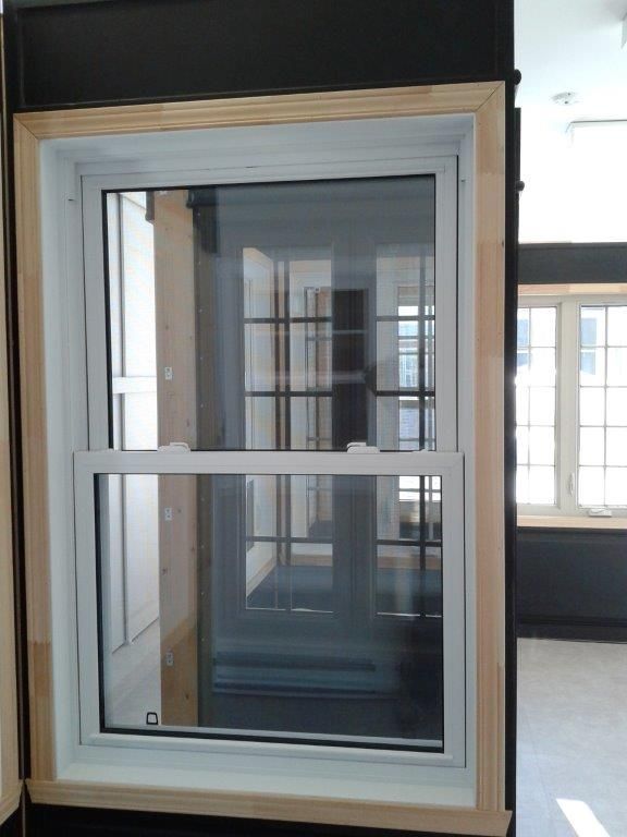 Une fenêtre avec un cadre en bois se trouve dans une pièce