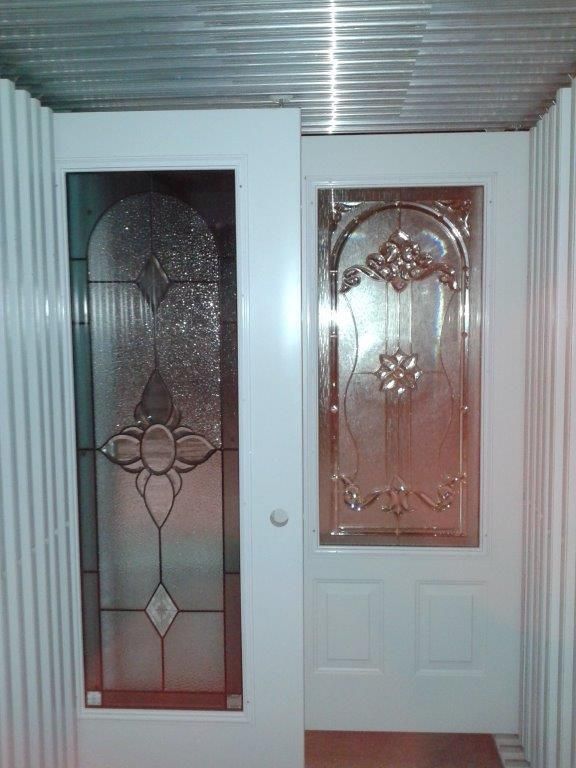 Une porte blanche avec un vitrail dans une pièce.