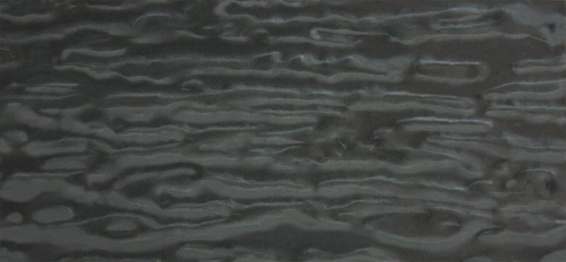 Surface texturée gris foncé avec des motifs horizontaux tourbillonnants.