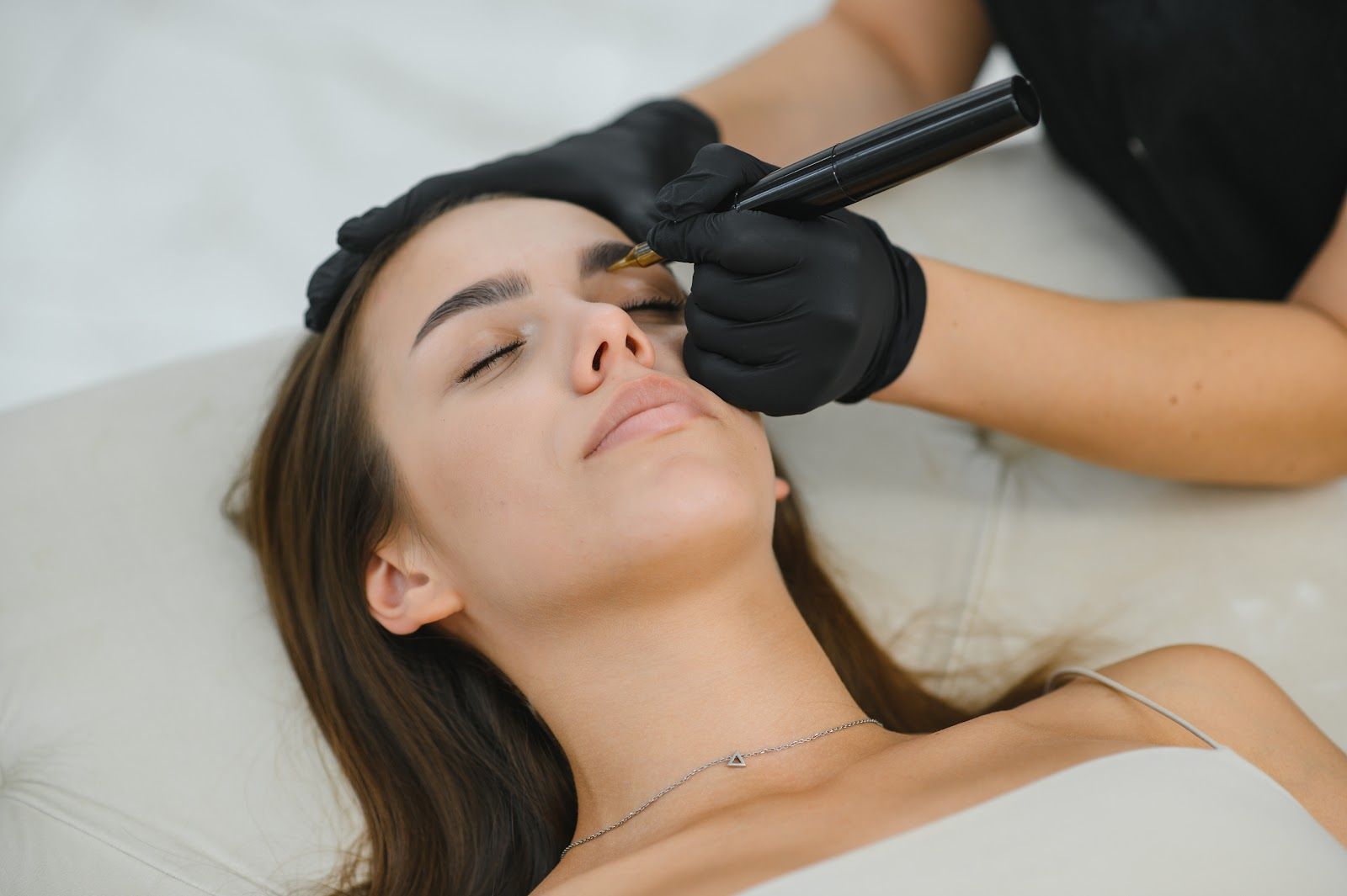 Woman receiving a cosmetic facial treatment while lying on a spa bed