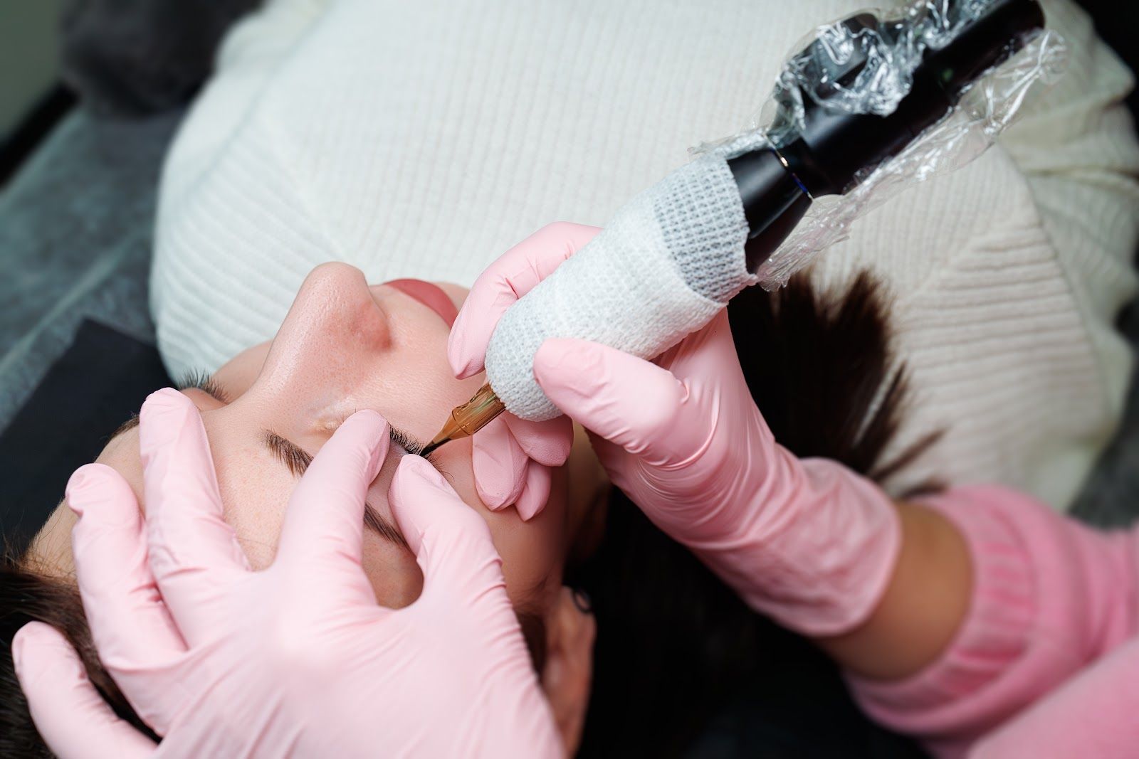 Dental procedure on a patient’s mouth with gloved hands and a dental tool wrapped in black tape