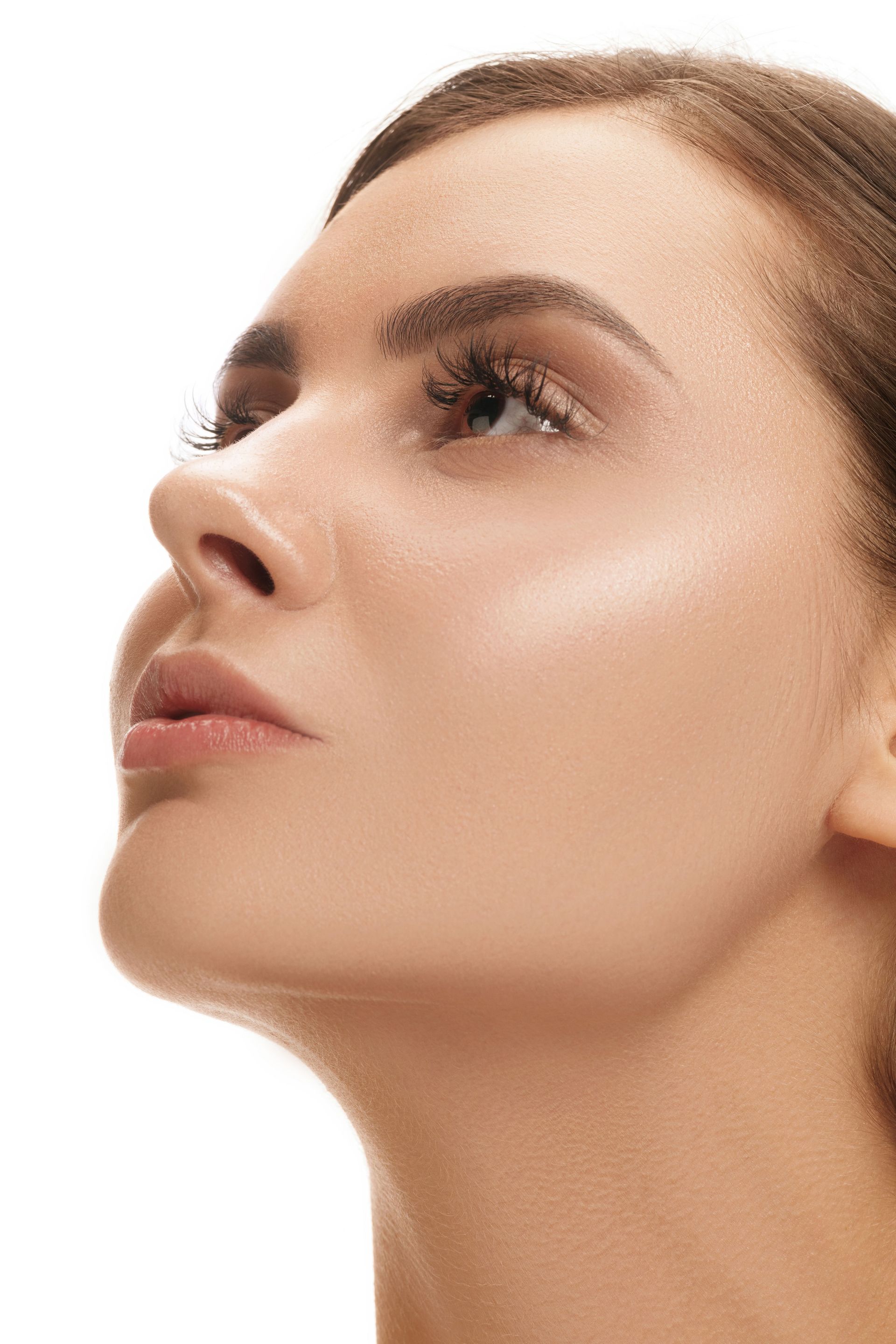 a close up of a woman 's face on a white background looking up .