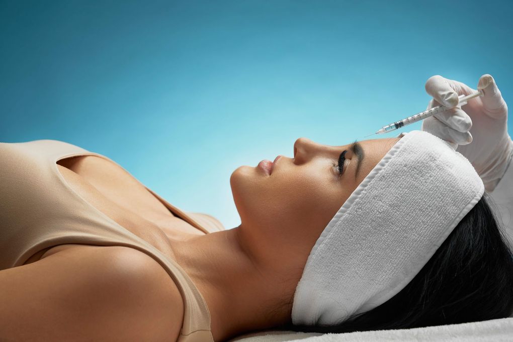 a woman is getting a botox injection in her face .