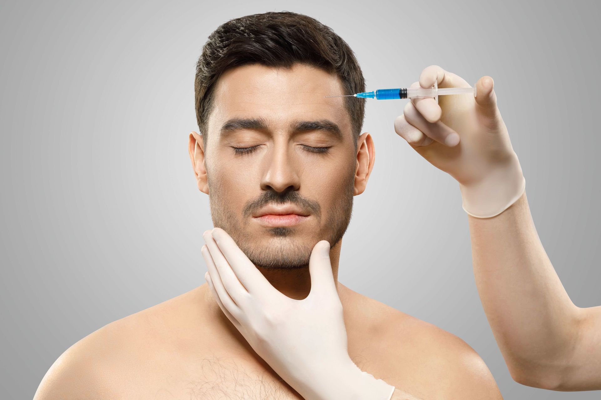 a man is getting a botox injection in his forehead .