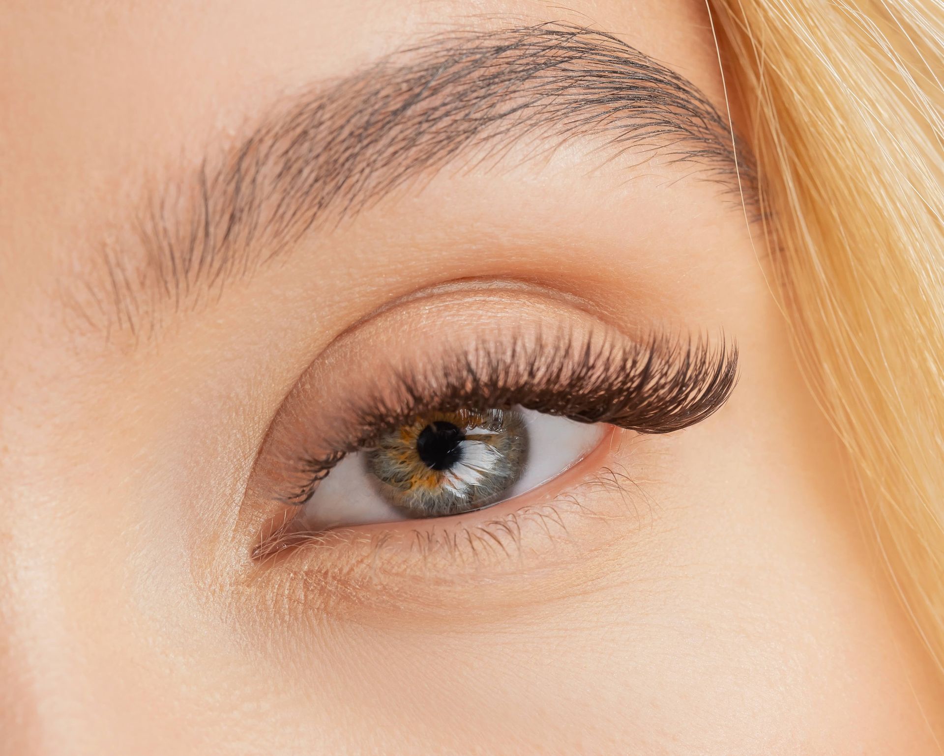 a close up of a woman 's eye with long eyelashes .