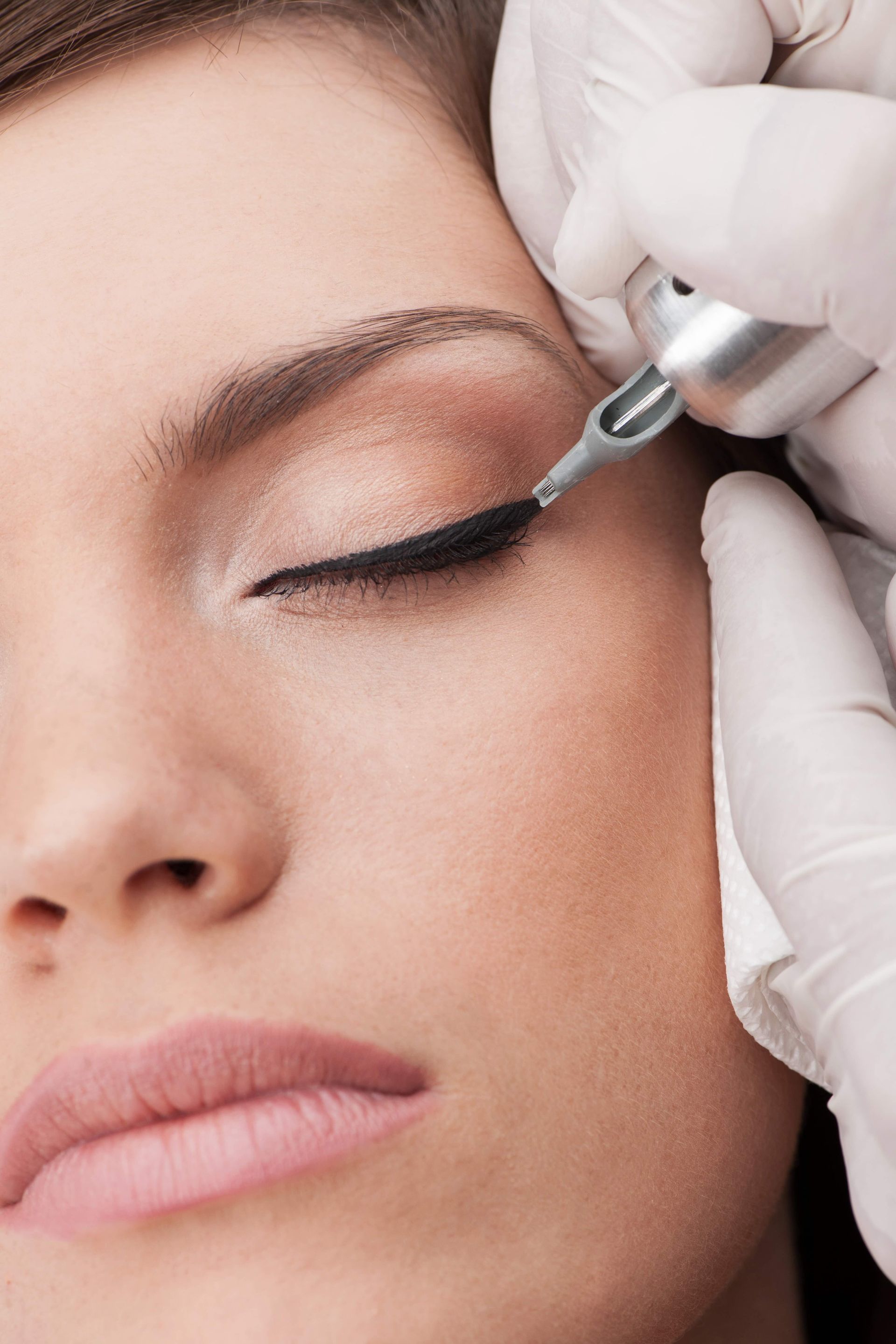a woman is getting an eyeliner tattoo on her eye