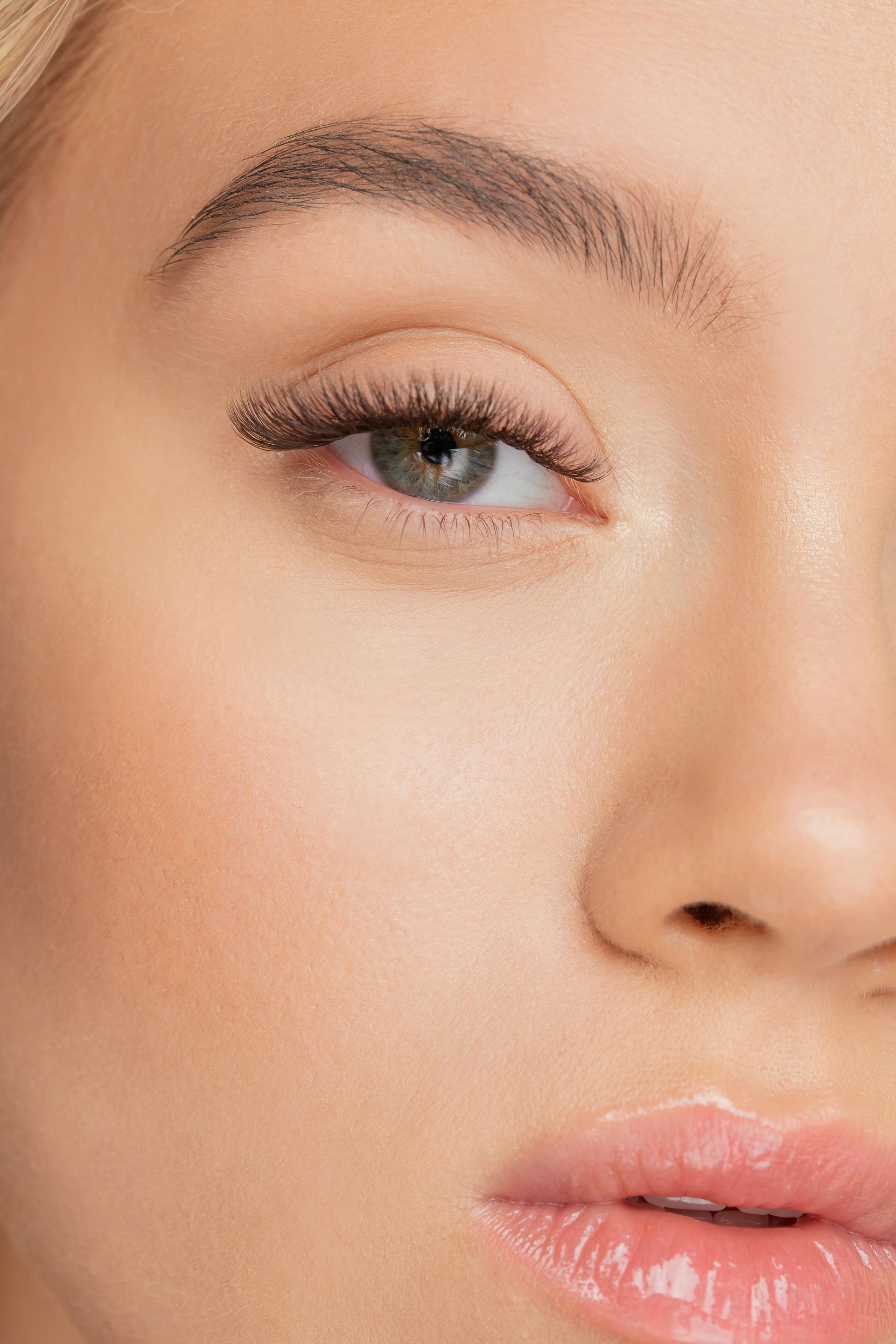 a close up of a woman 's face with long eyelashes and pink lips .