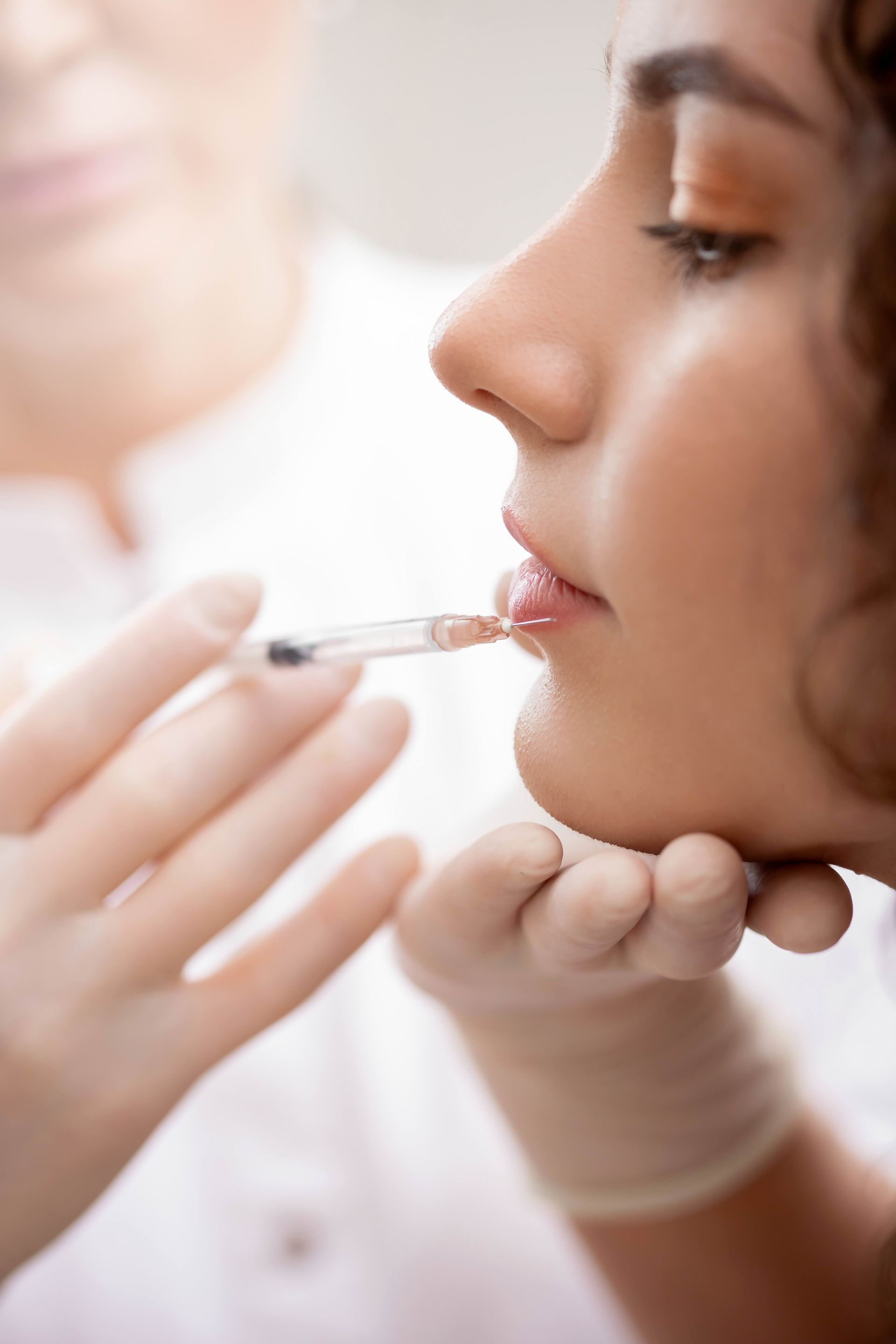 a woman is getting a botox injection in her lips .