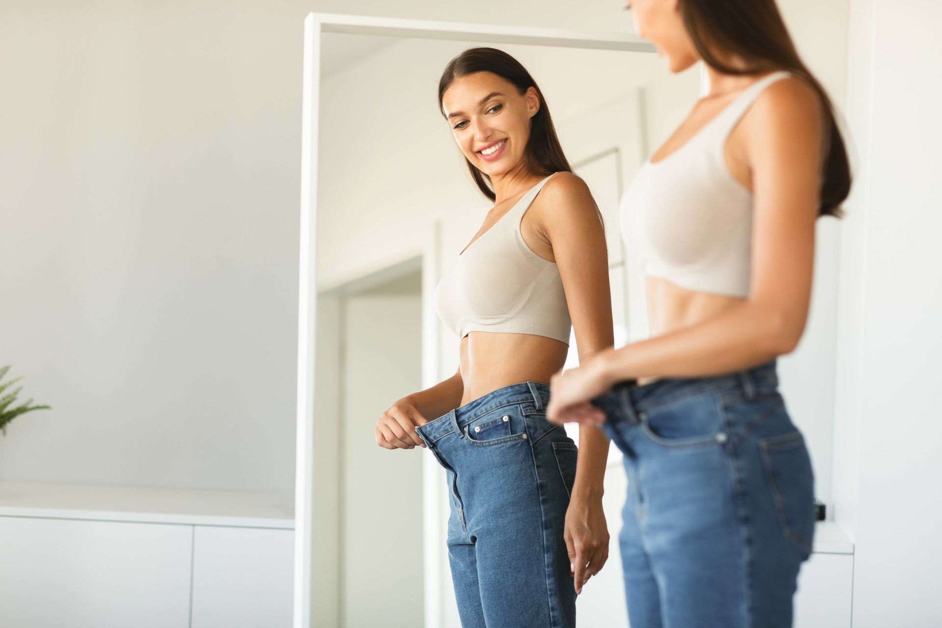 a woman is looking at her reflection in a mirror .