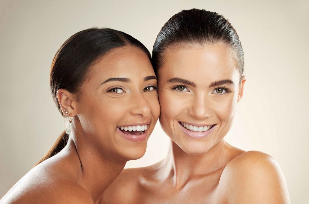 two beautiful women are posing for a picture together and smiling .