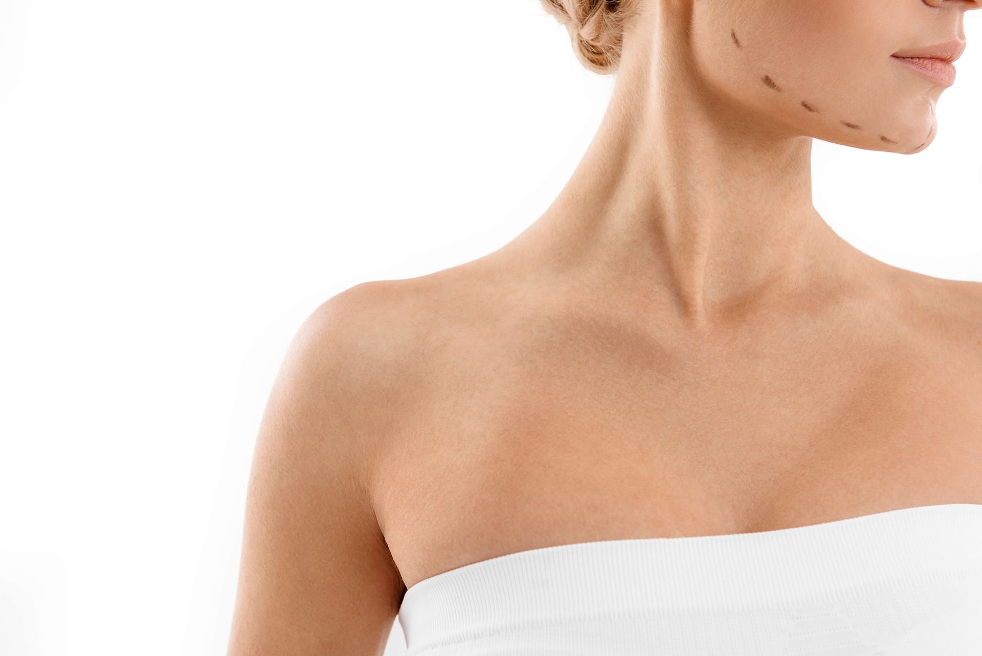 a woman with markings on her face is wearing a white strapless top .