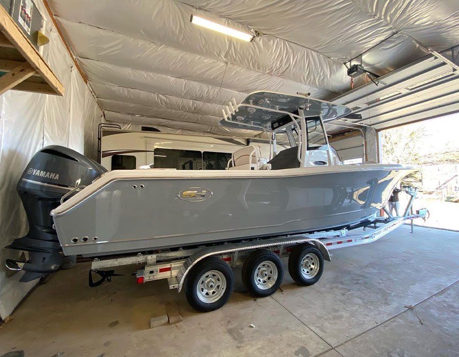 A boat is parked in a garage with a trailer attached to it.