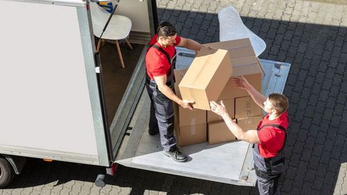 Two men are loading boxes into a truck.