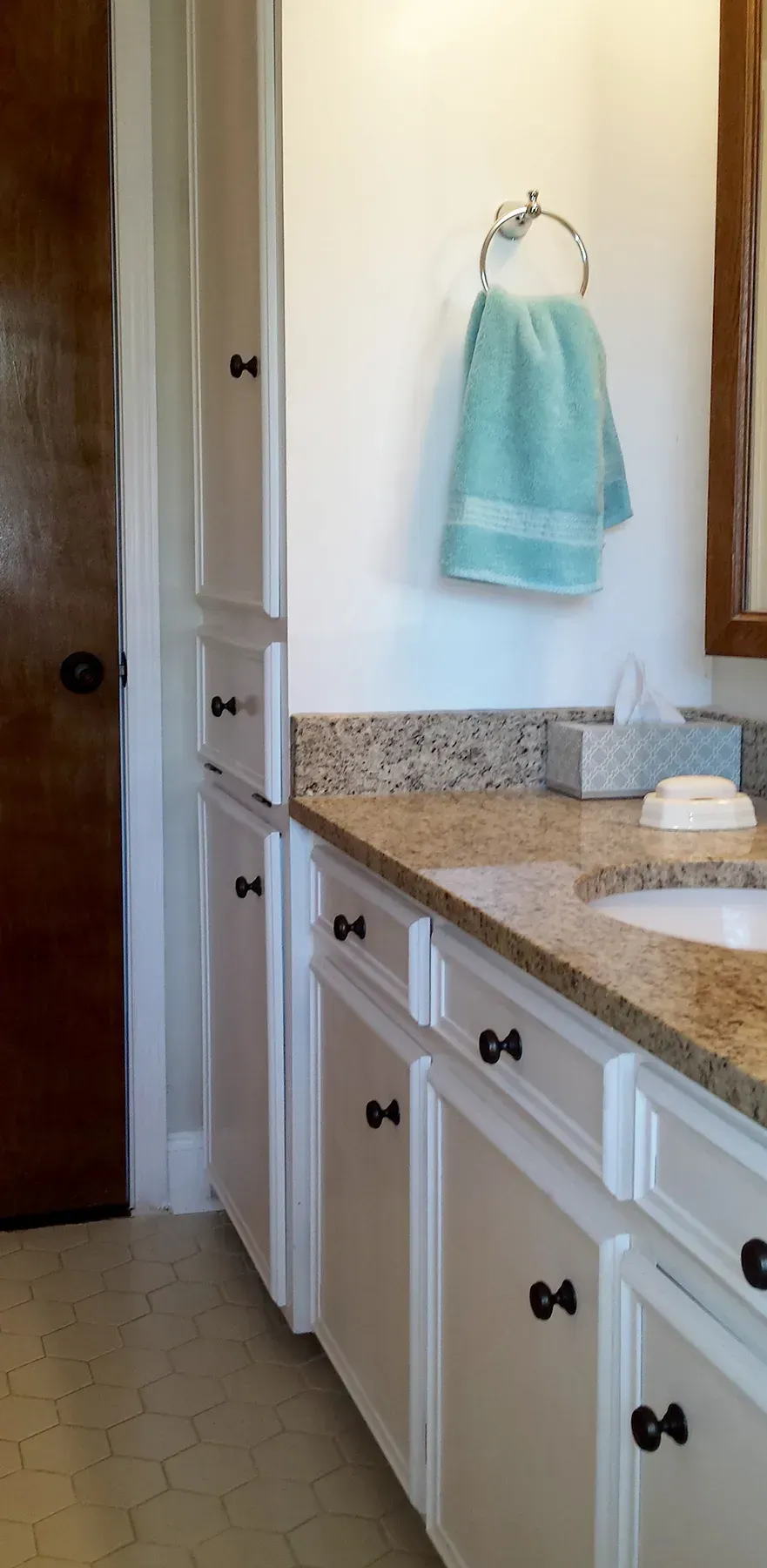 A Bathroom With A Sink And A Towel Hanging On The Counter - Raymond, MS - Parker Roofing & Remodeling