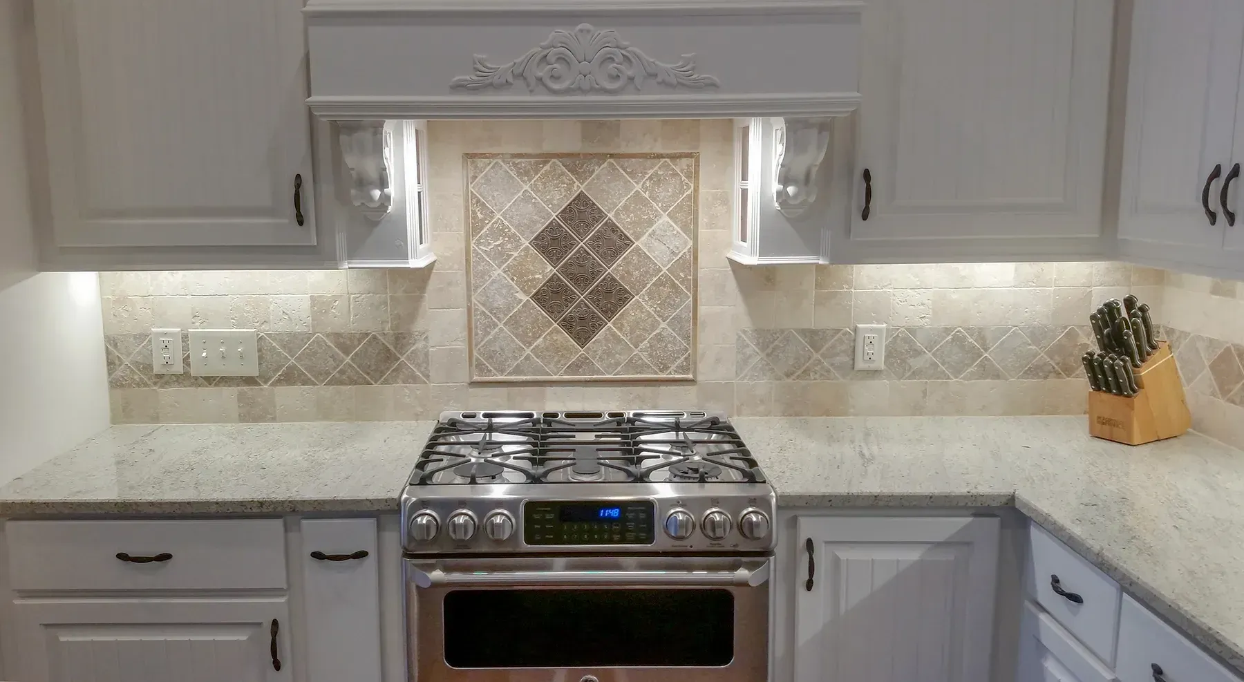 A Kitchen With White Cabinets And A Stove Top Oven - Raymond, MS - Parker Roofing & Remodeling
