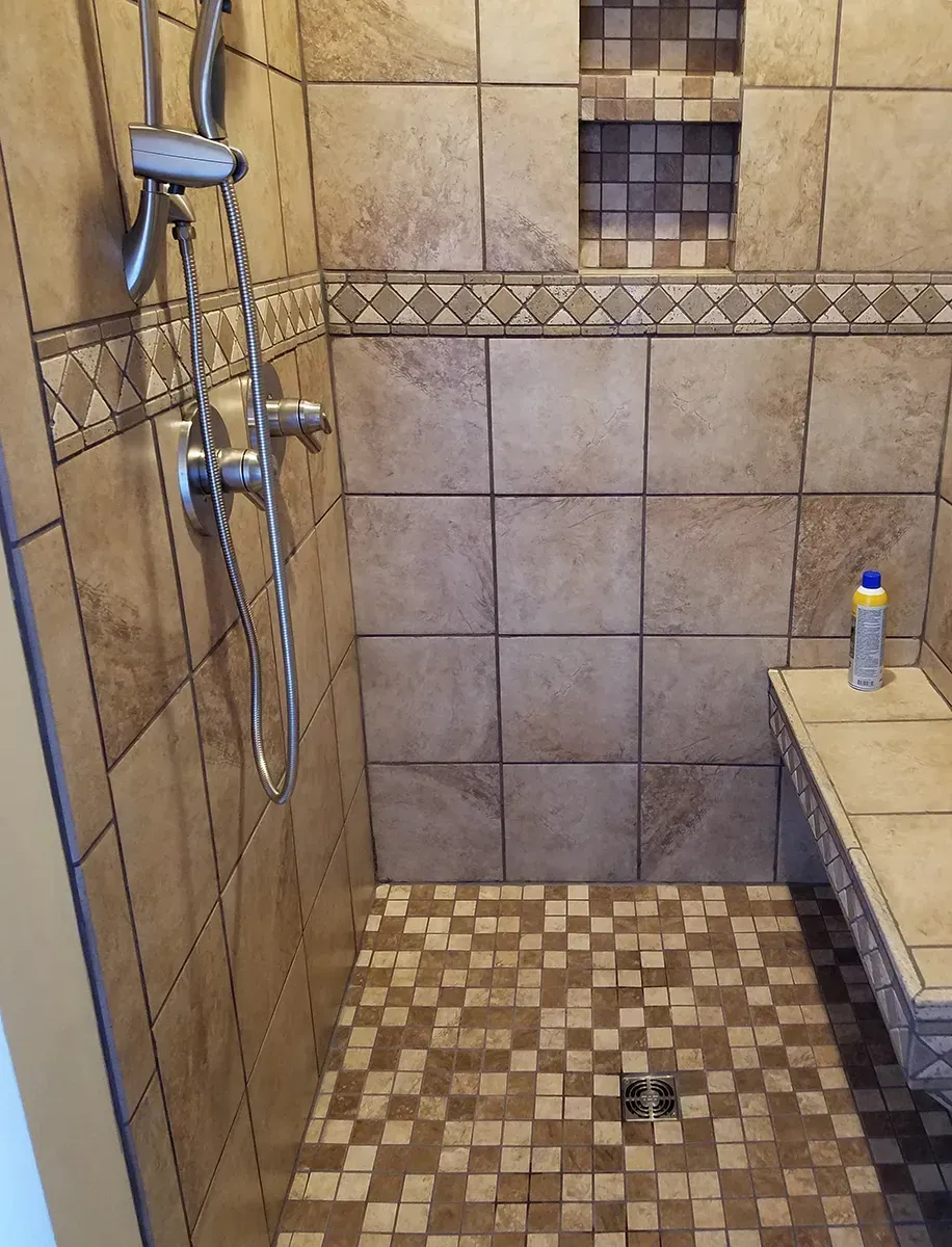 A Bathroom With A Walk In Shower And A Bench - Raymond, MS - Parker Roofing & Remodeling