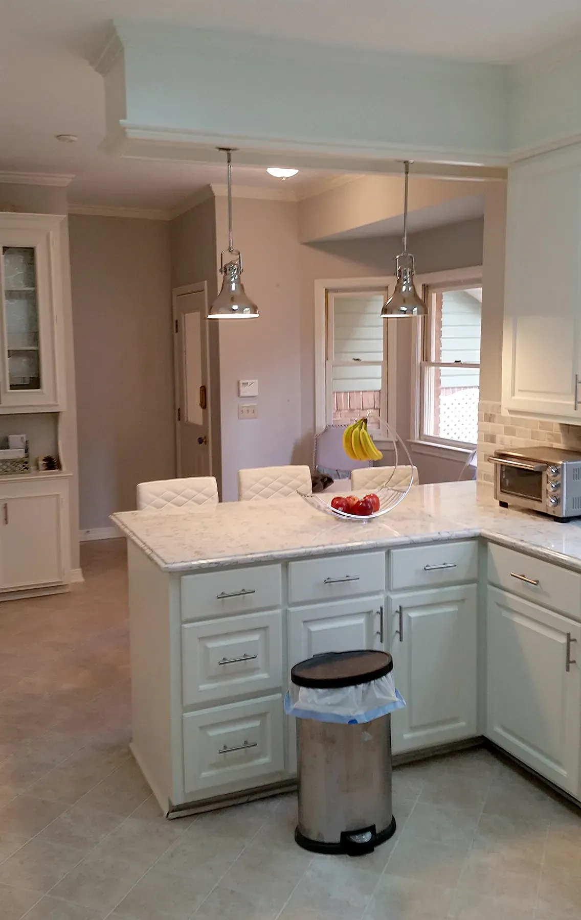 A Kitchen With White Cabinets And A Stainless Steel Trash Can - Raymond, MS - Parker Roofing & Remodeling