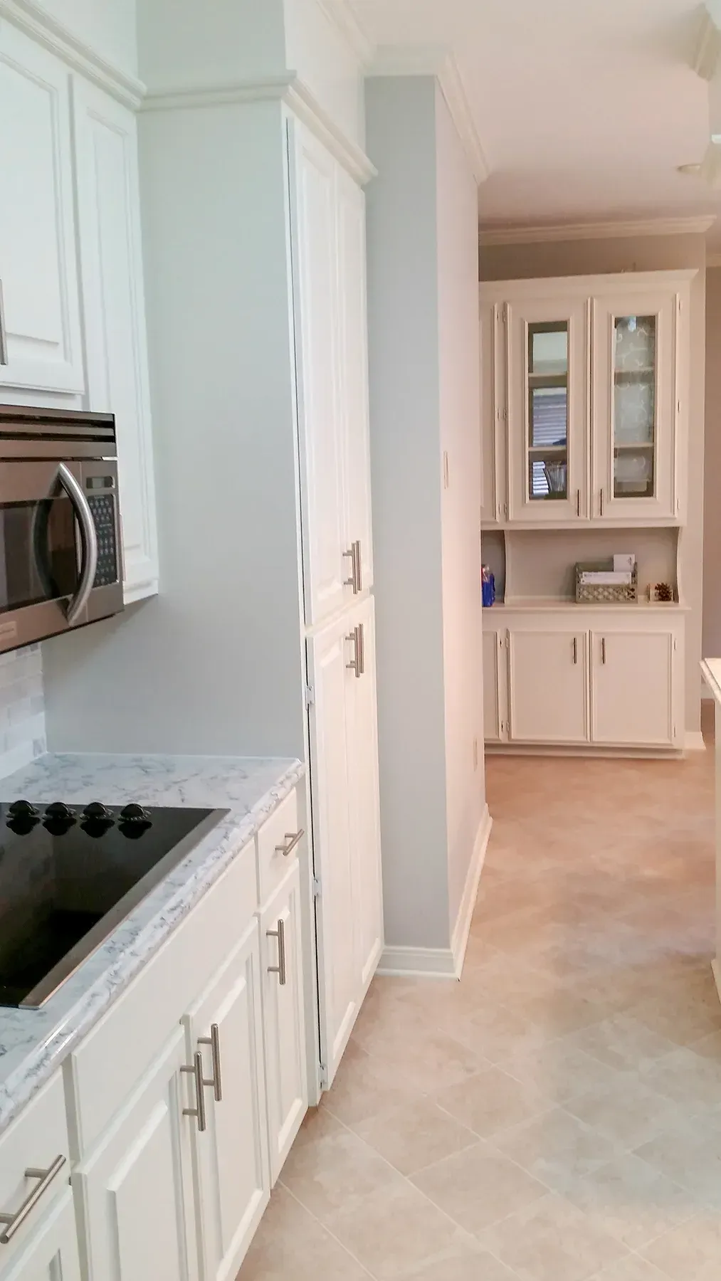 A Kitchen With White Cabinets, A Microwave, And A Sink - Raymond, MS - Parker Roofing & Remodeling