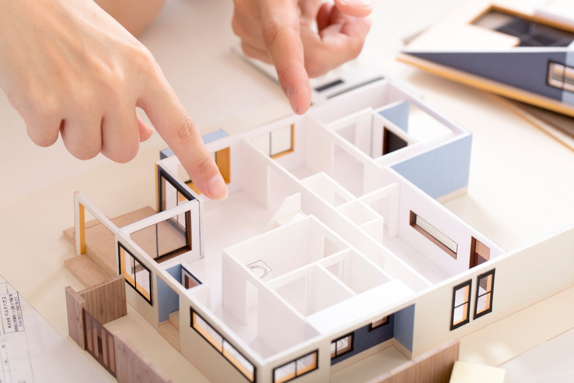 A person is pointing at a model of a house.