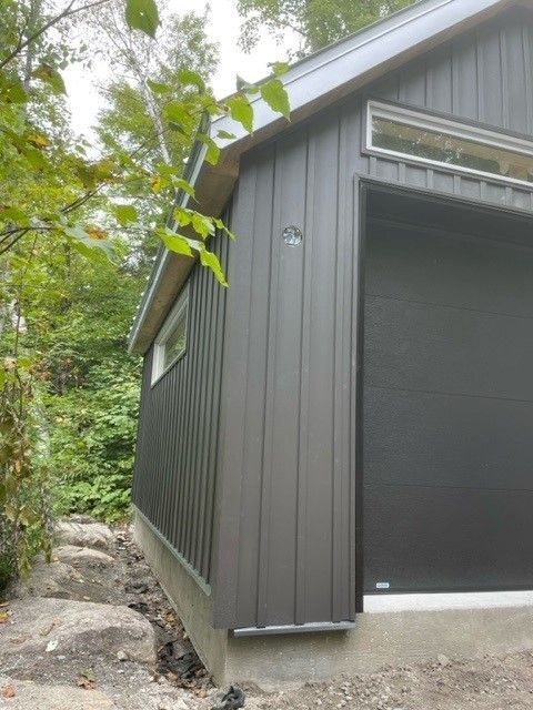 Un garage noir avec une porte de garage et une fenêtre