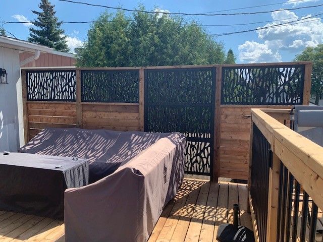 Une terrasse en bois avec un canapé et un bain à remous.