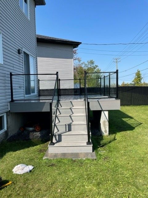 Une terrasse avec des escaliers qui y mènent se trouve dans la cour d'une maison.