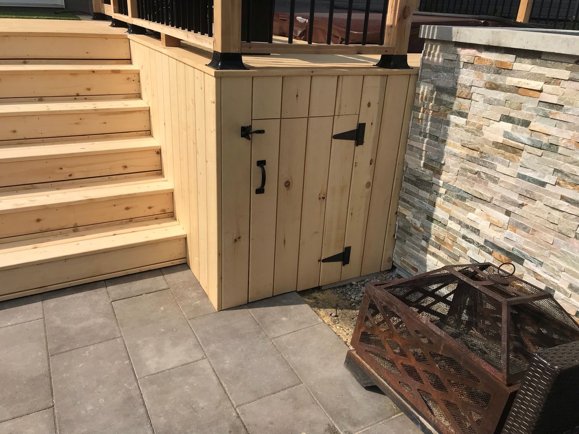 Une terrasse en bois avec des escaliers et un foyer.
