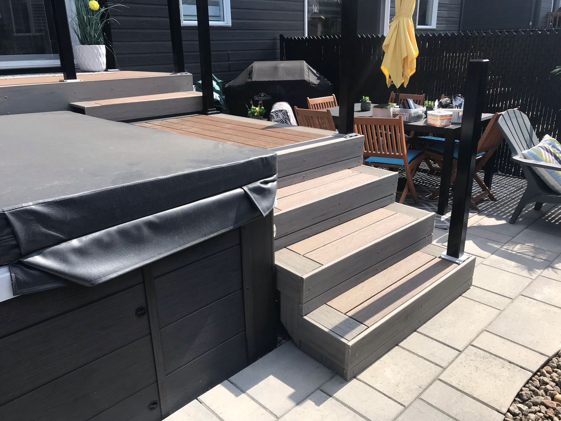 Un bain à remous est posé au sommet d'une terrasse en bois avec des escaliers qui y mènent.
