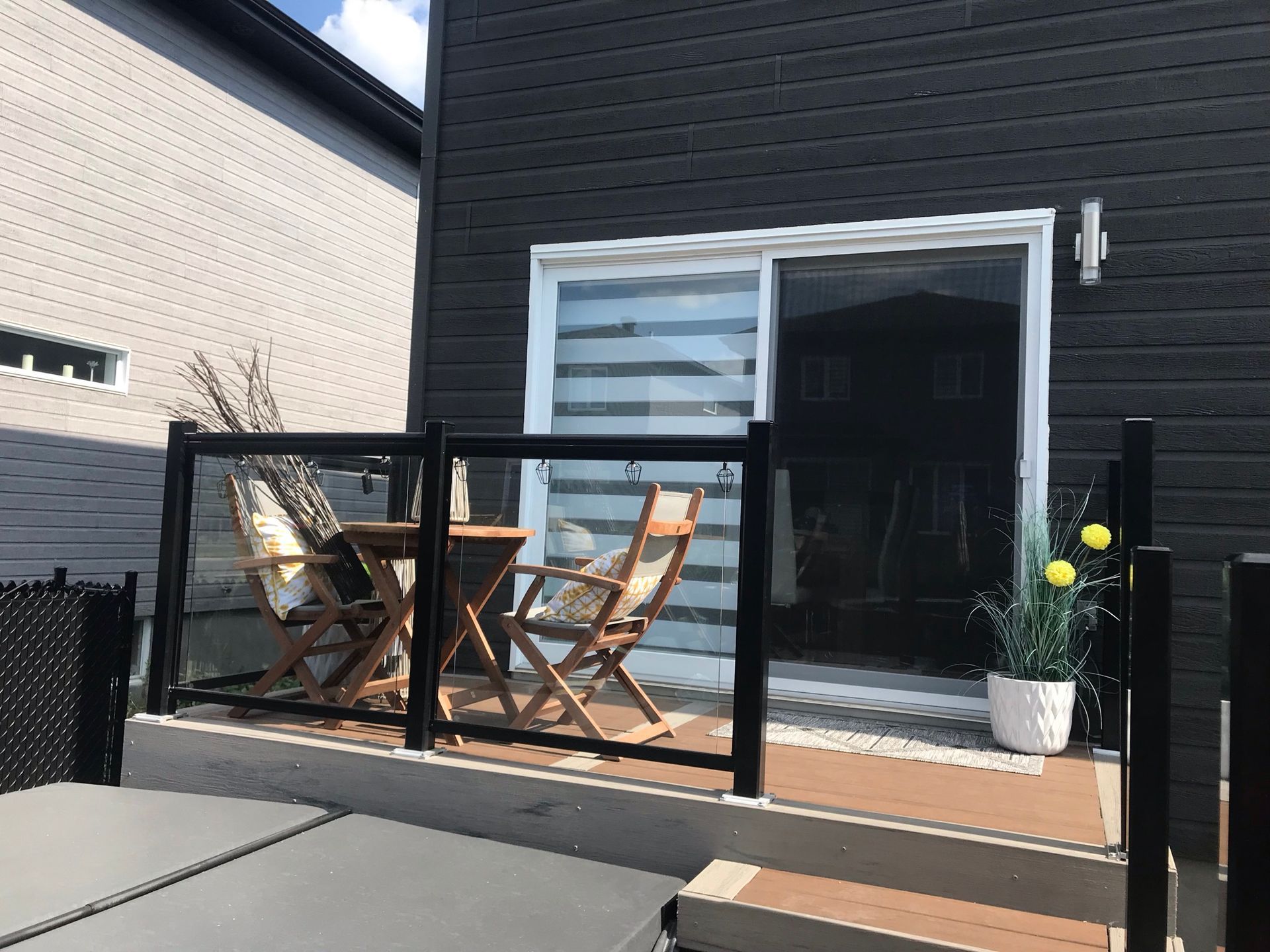 Un patio avec une table et des chaises et une porte coulissante vitrée.