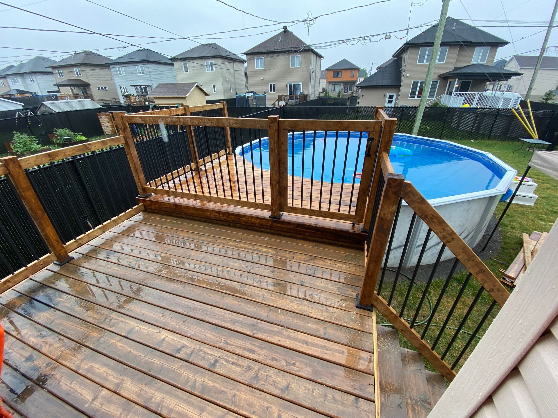 Une grande piscine est entourée d'une terrasse en bois.