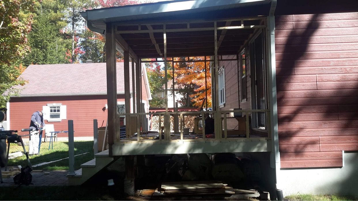 Une maison rouge avec une véranda en construction