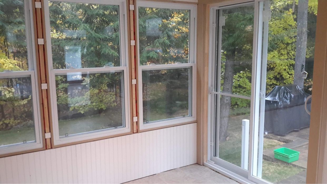Une pièce avec beaucoup de fenêtres et de portes coulissantes en verre.