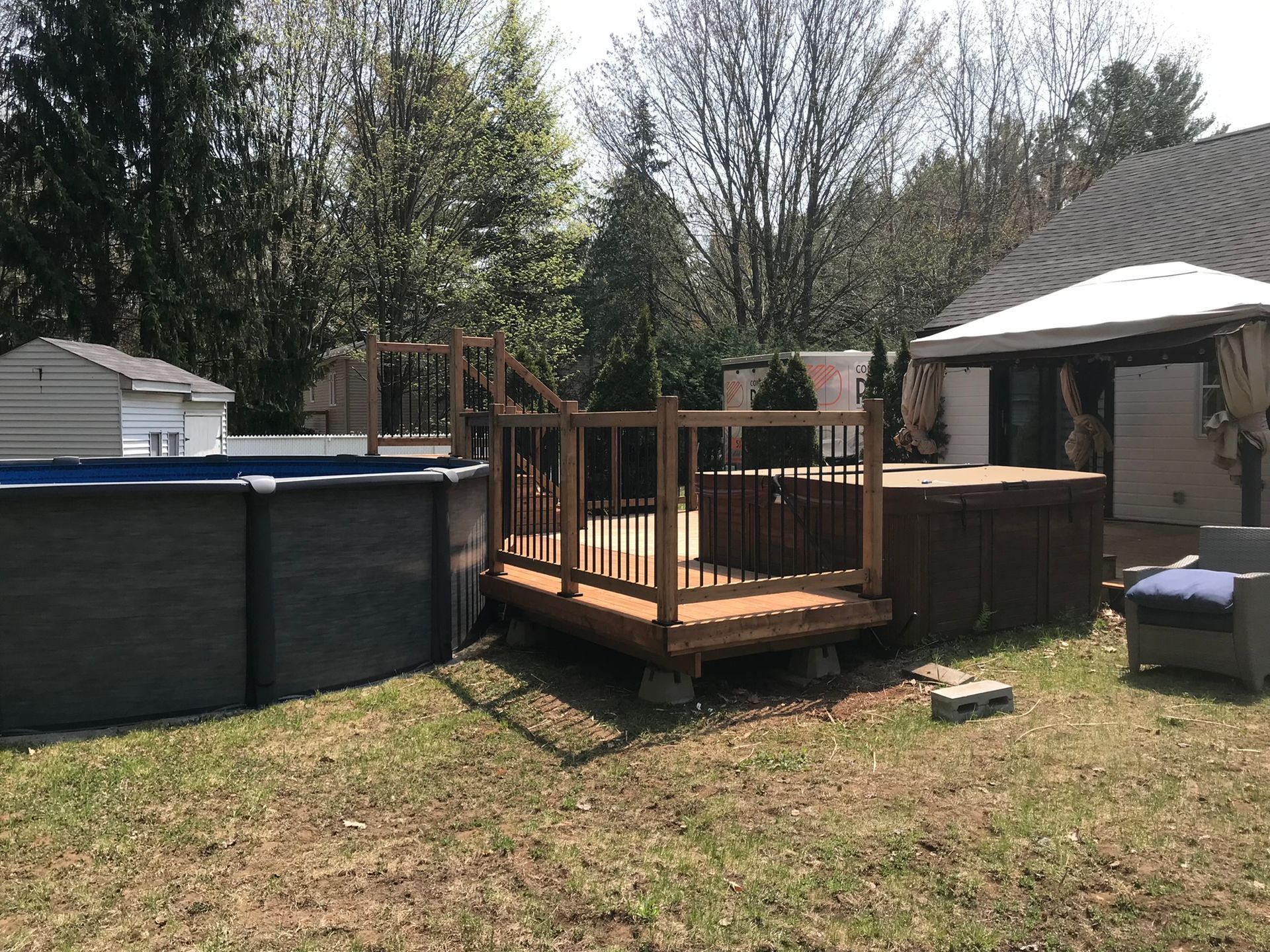 Une terrasse en bois se trouve à côté d'une piscine dans une cour.
