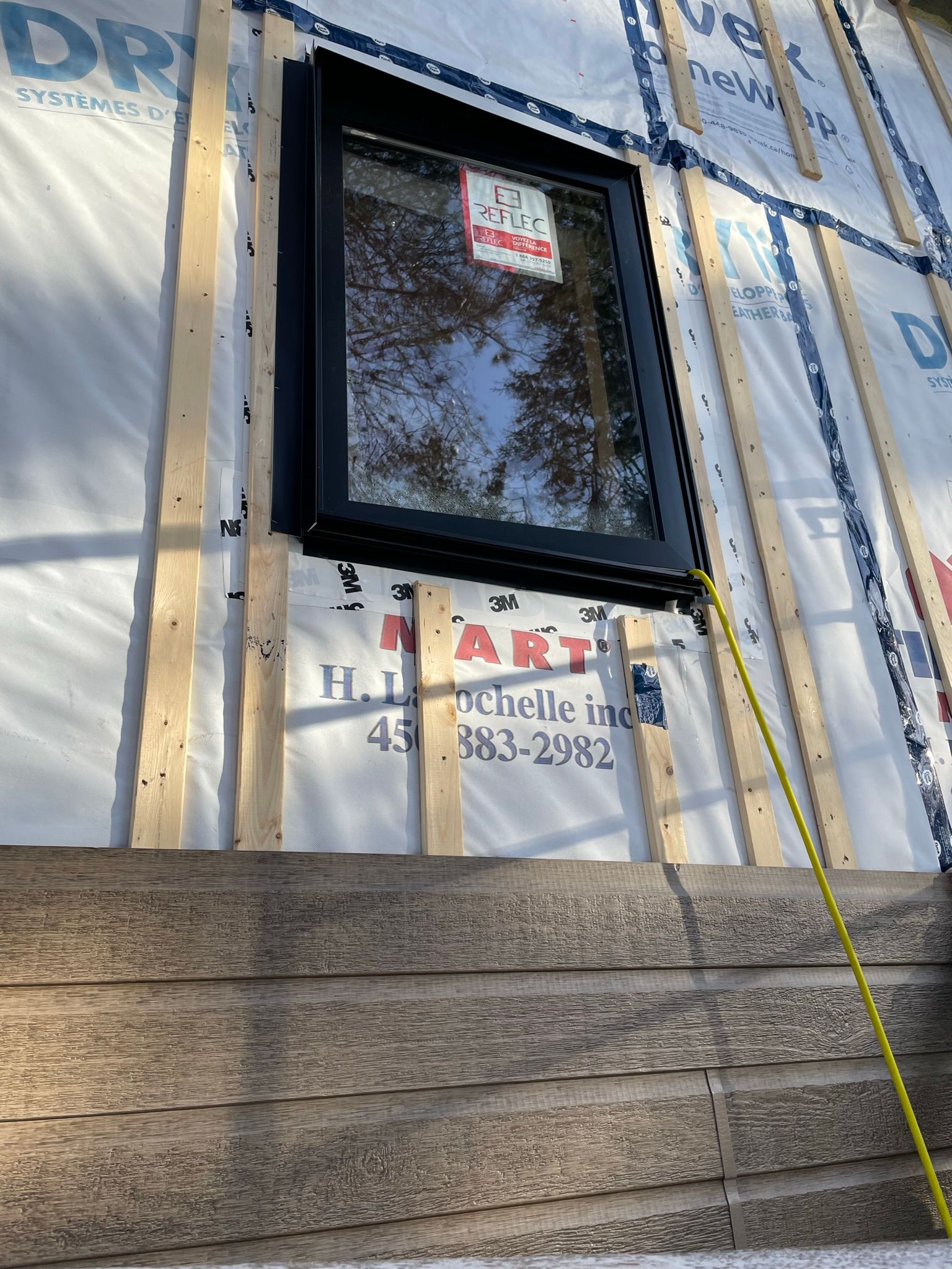 Une fenêtre est en cours d'installation sur le côté d'une maison.