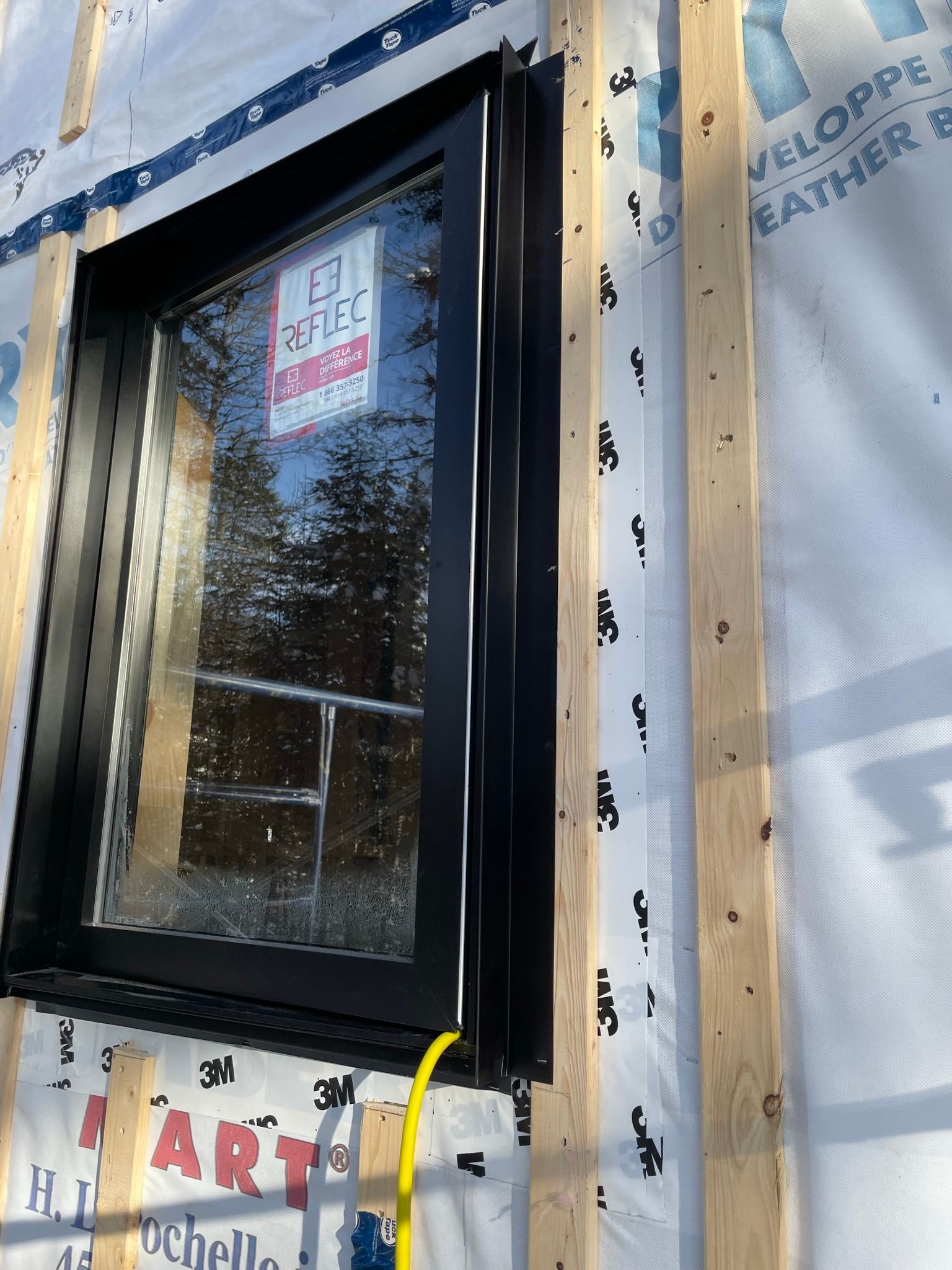 Une fenêtre est en cours d'installation sur le côté d'une maison