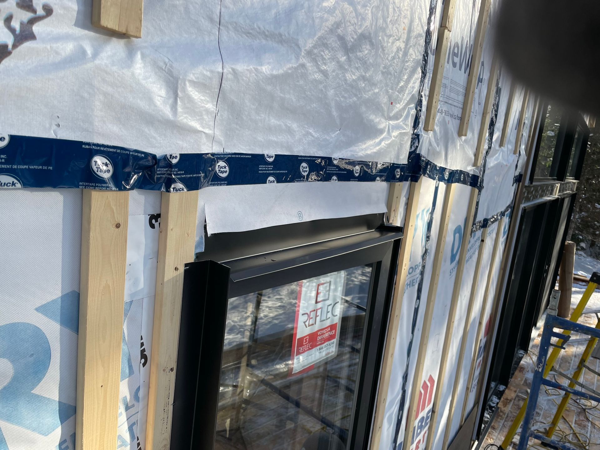 Une fenêtre est en cours d'installation sur le côté d'un immeuble.