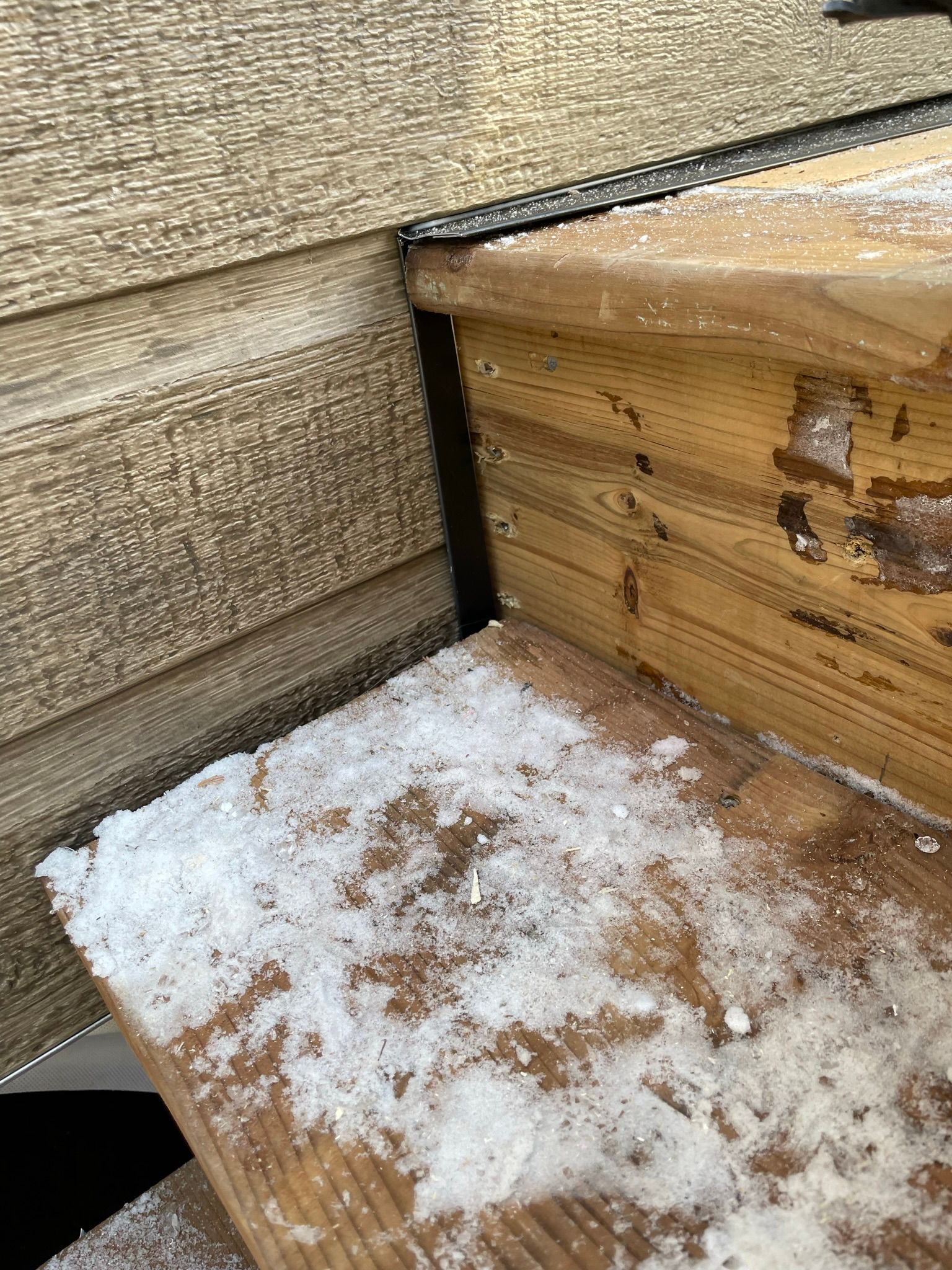 Un gros plan d'un banc en bois avec de la neige dessus.