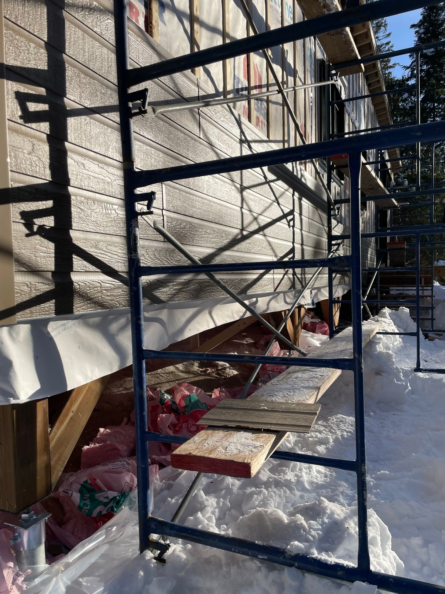 Un échafaudage est utilisé pour construire une maison dans la neige.