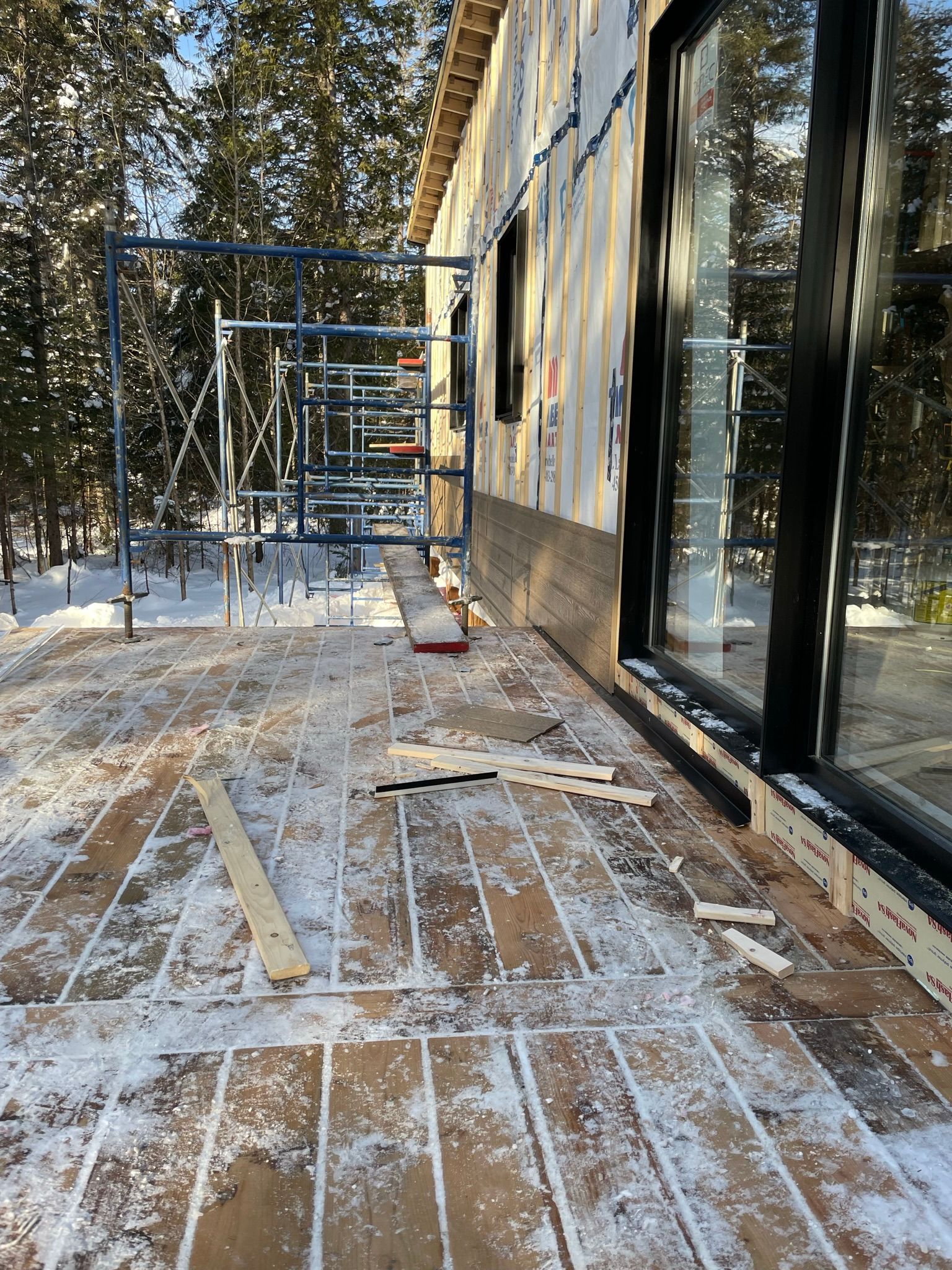 Un bâtiment en construction dans la neige avec un échafaudage en arrière-plan.