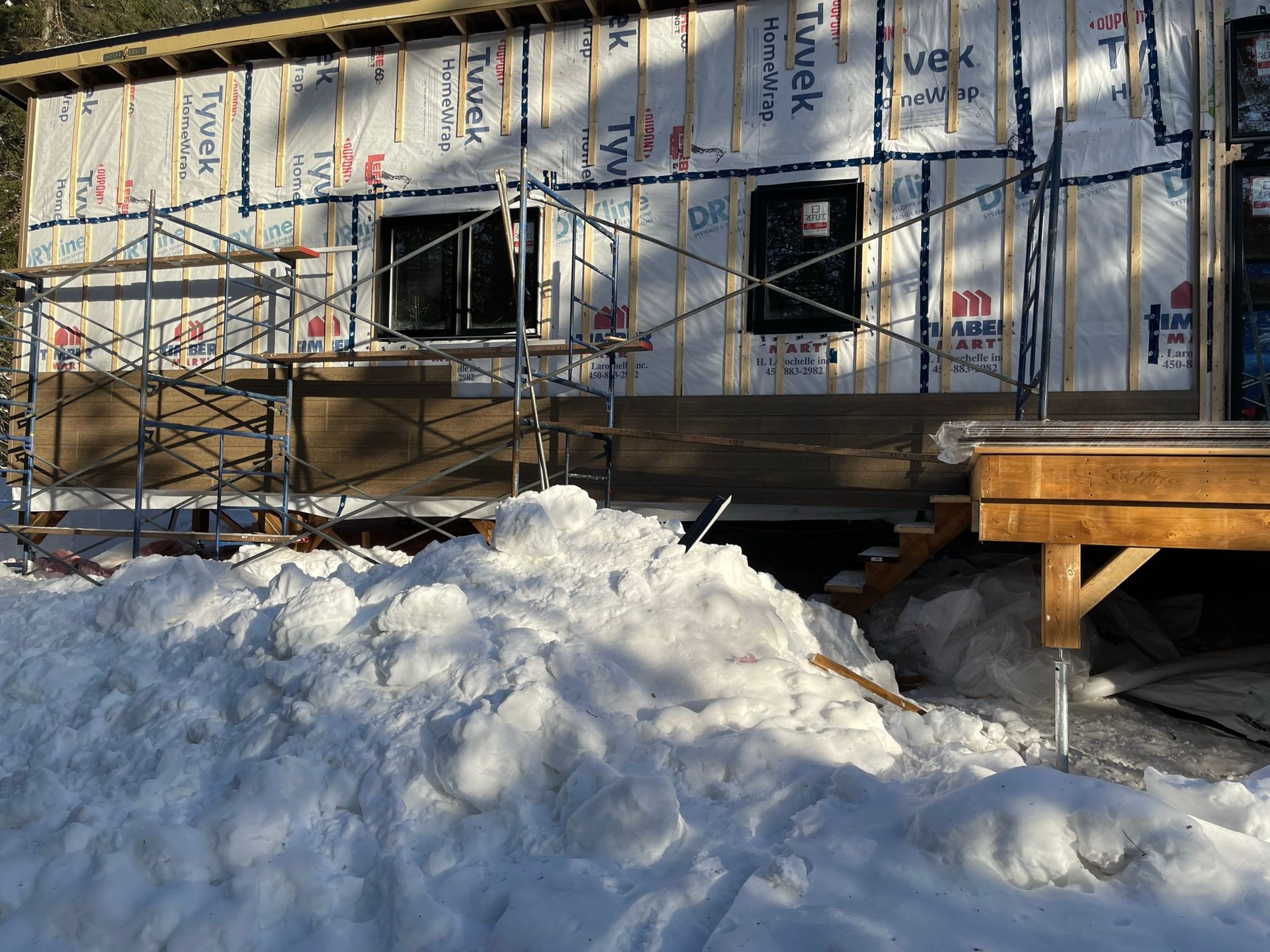 Un gros tas de neige se trouve devant une maison en construction.