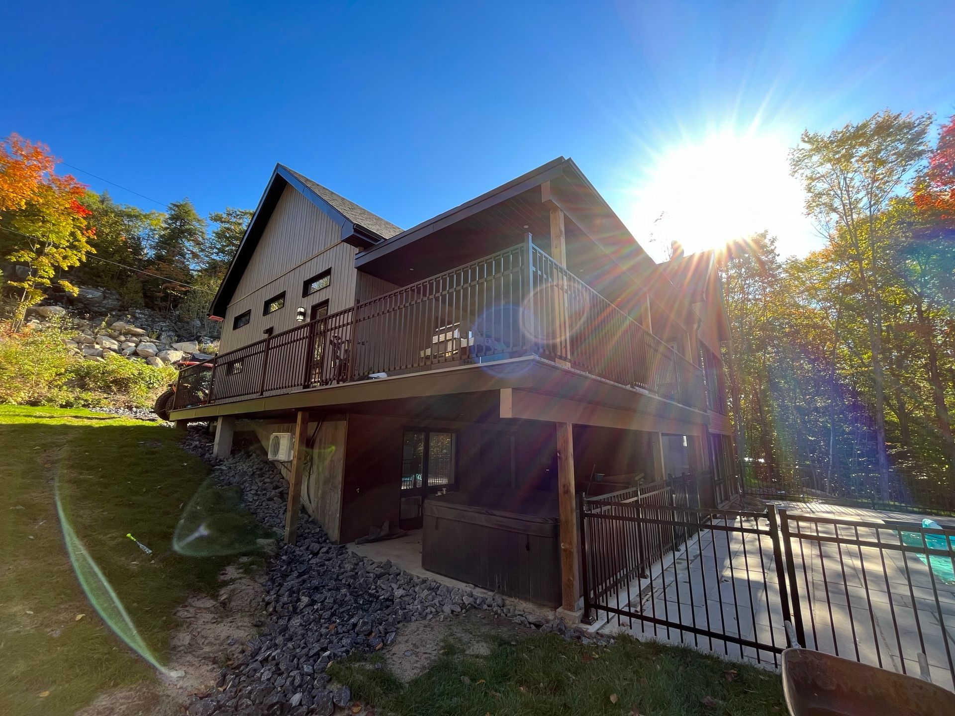 Une grande maison avec un balcon et une clôture devant.