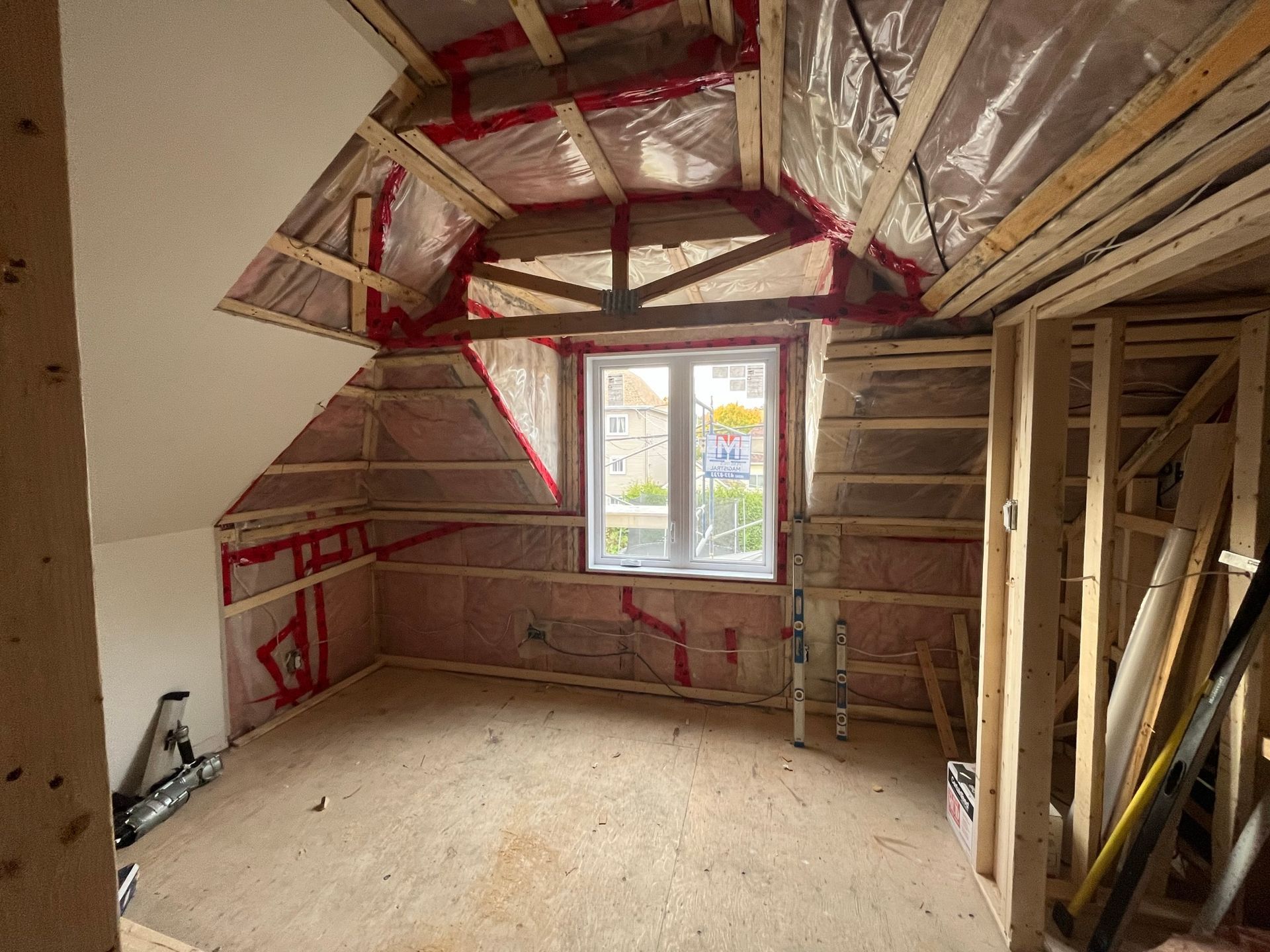 Une chambre dans une maison en construction avec une fenêtre.