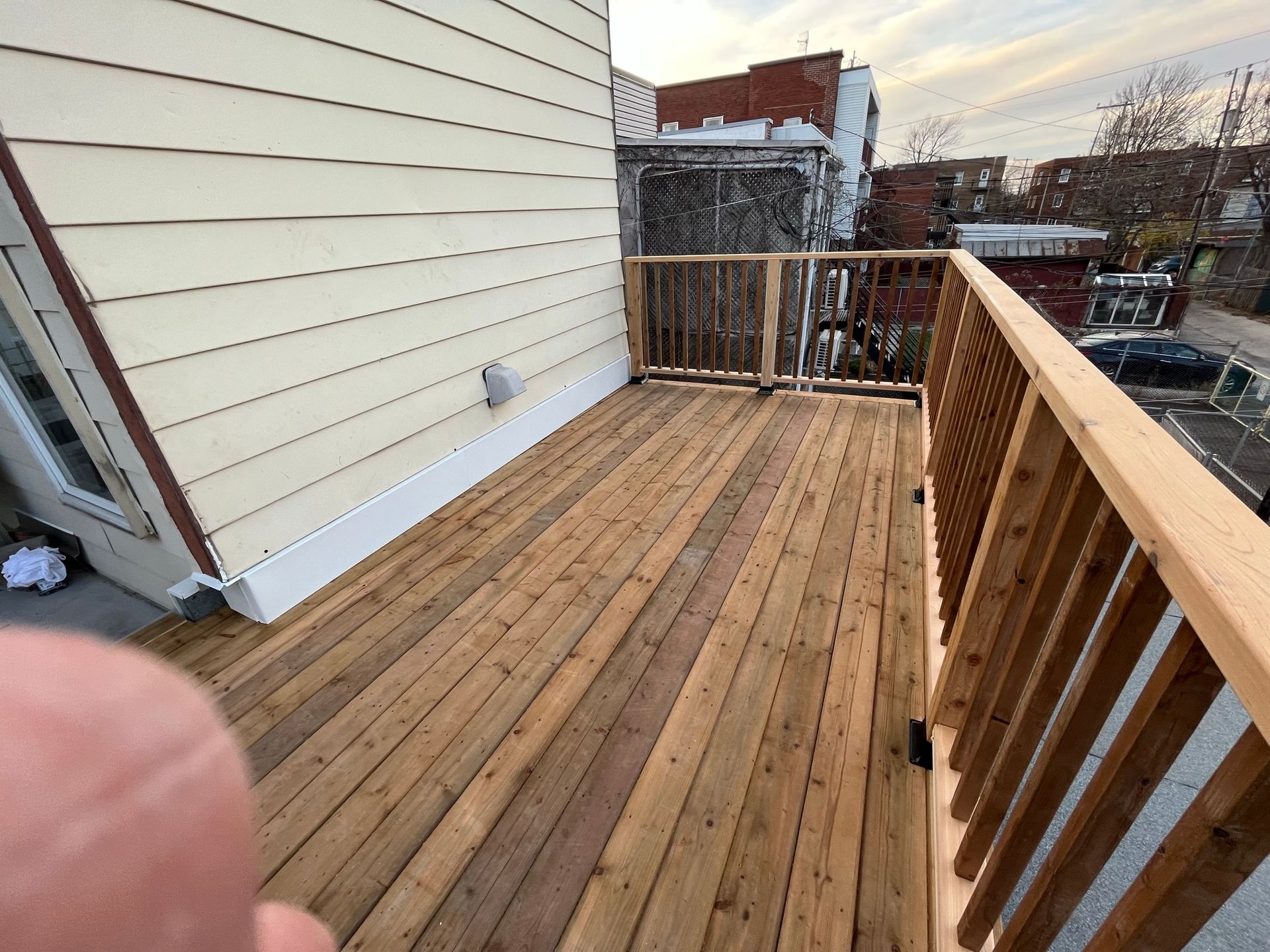 Une terrasse en bois avec une balustrade sur le côté d'une maison.